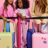 Three children with colorful skootcase suitcases against a pink background with skoot colors alphabet stickers