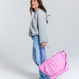 Madi nelson smiling holding the skoot pink gingham tote bag pink gingham