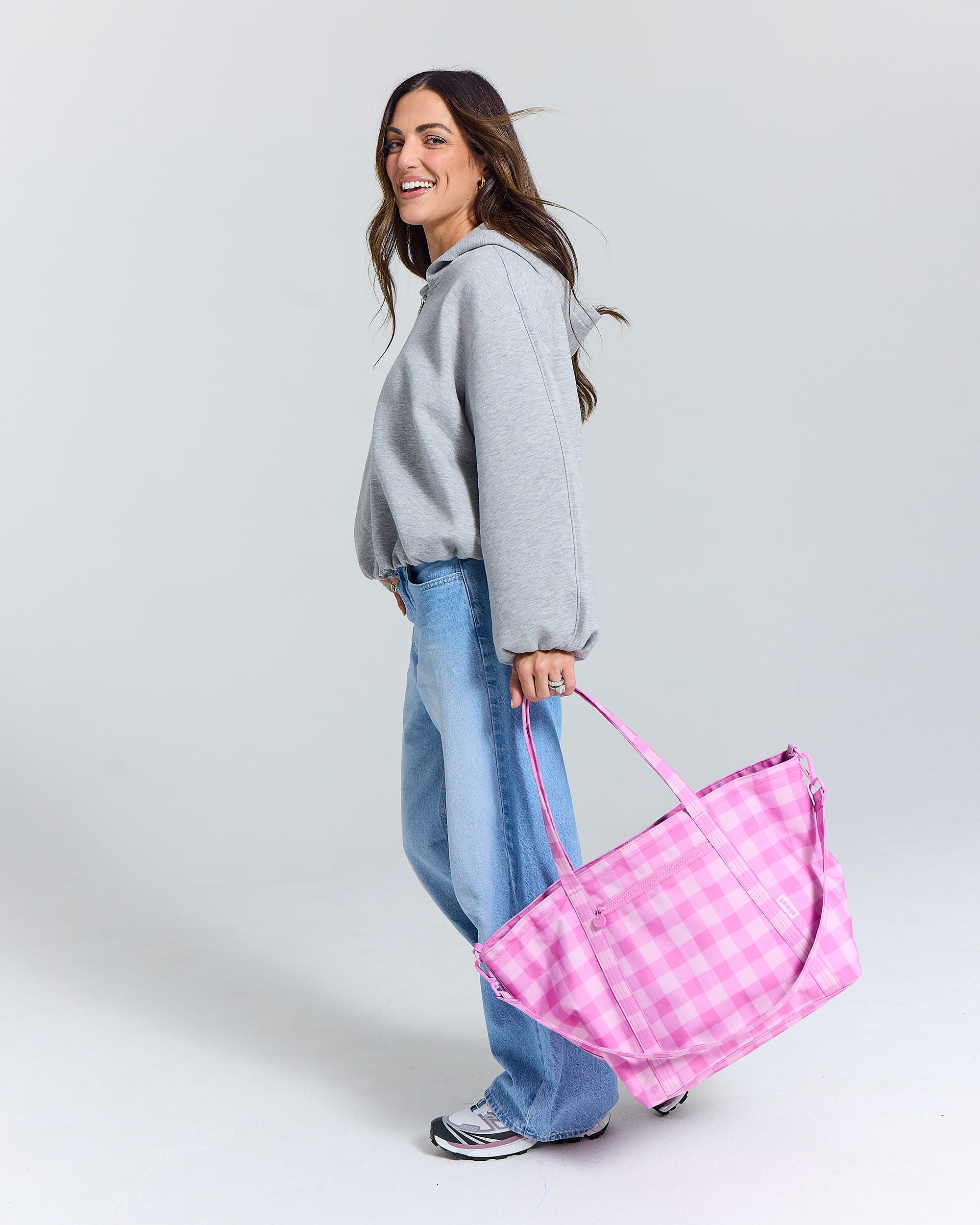 Madi nelson smiling holding the skoot pink gingham tote bag pink gingham