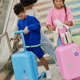 Skoot kids riding skootcases at airport with skoot colors travel stickers